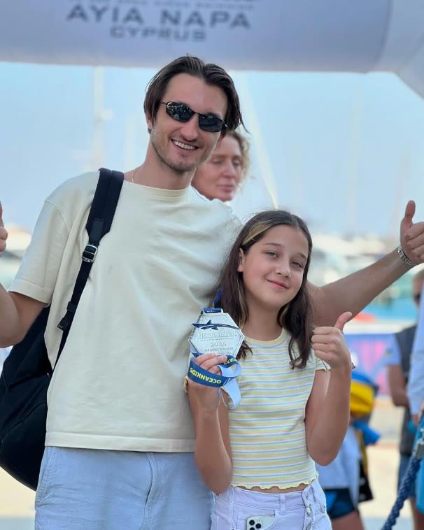A coach and a girl at the OCEANMAN Ayia Napa finish arch, thumbs up